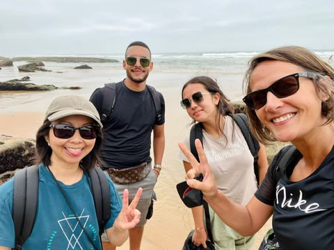 Marouane sur la plage avec trois voyageuses souriantes