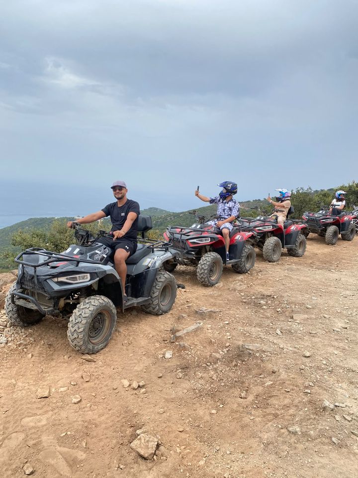 Marouane et des voyageurs en quad sur une piste au-dessus de la mer